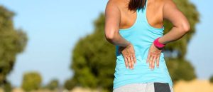 woman runner holding her lower back in pain