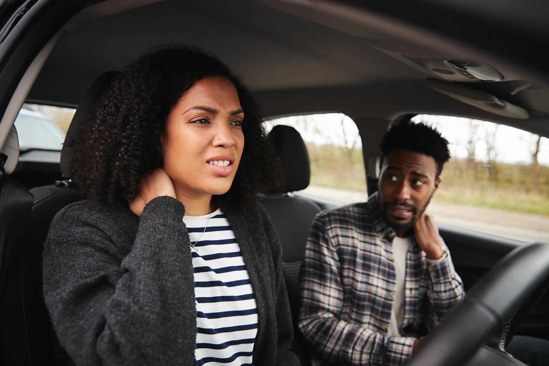 Couple in car with whiplash injury and neck pain