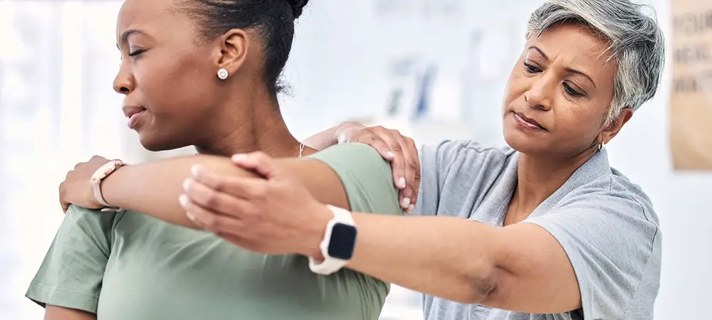 Chiropractor stretching woman's shoulder