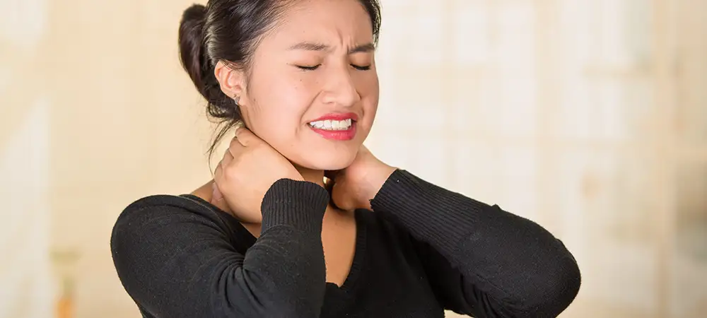 Woman holding neck in pain